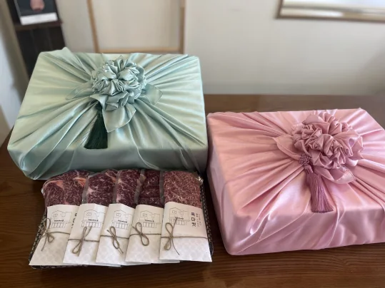 민트색·분홍색 보자기로 싼 선물 상자 둘과, 끈으로 묶은 종이 띠를 두른 진공 포장 한우 다섯 팩